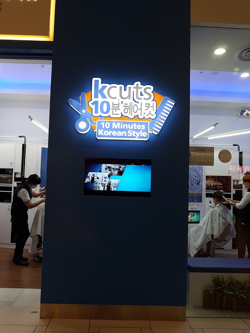 The kcuts shopfront features its illuminated logo and a glimpse of customers receiving haircuts inside.