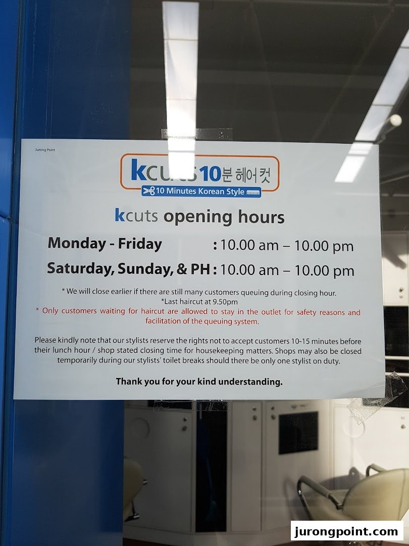 A sign displaying kcuts' opening hours and service policies at the shop entrance.