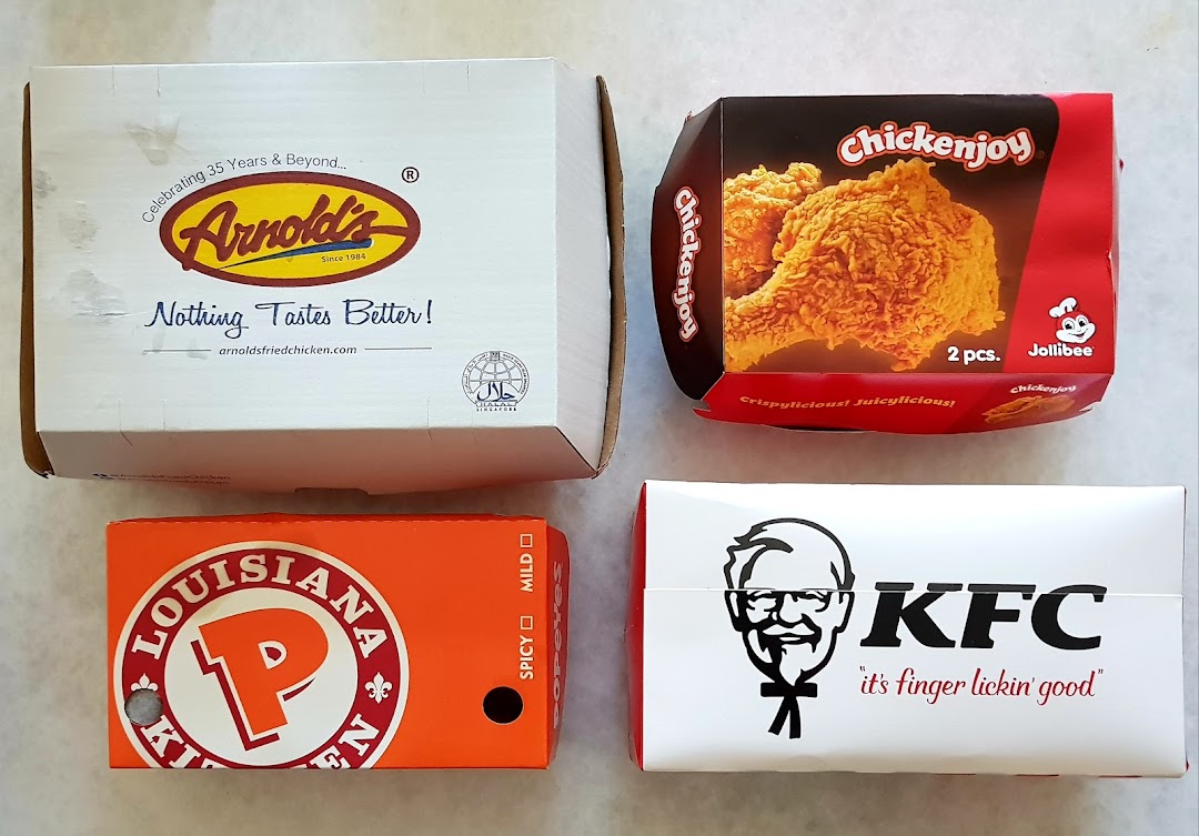 An overhead view of fried chicken packaging from Arnold's, Jollibee, Popeyes, and KFC.
