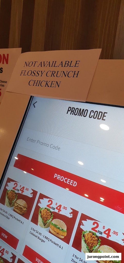 A KFC self-service kiosk displaying menu items, promotional offers, and a promo code entry screen.