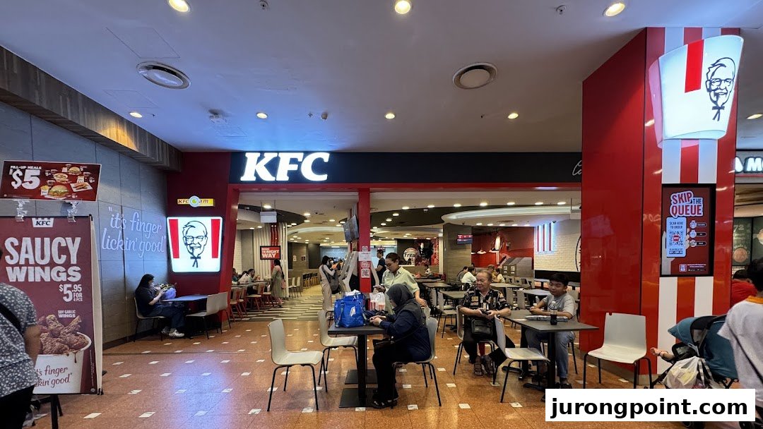 The KFC shop entrance in a mall, with customers seated at tables and promotional signs visible.