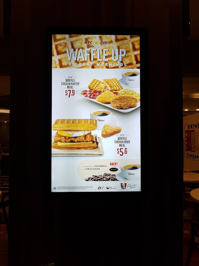 A digital menu board at KFC showcasing breakfast waffle meals and coffee options.