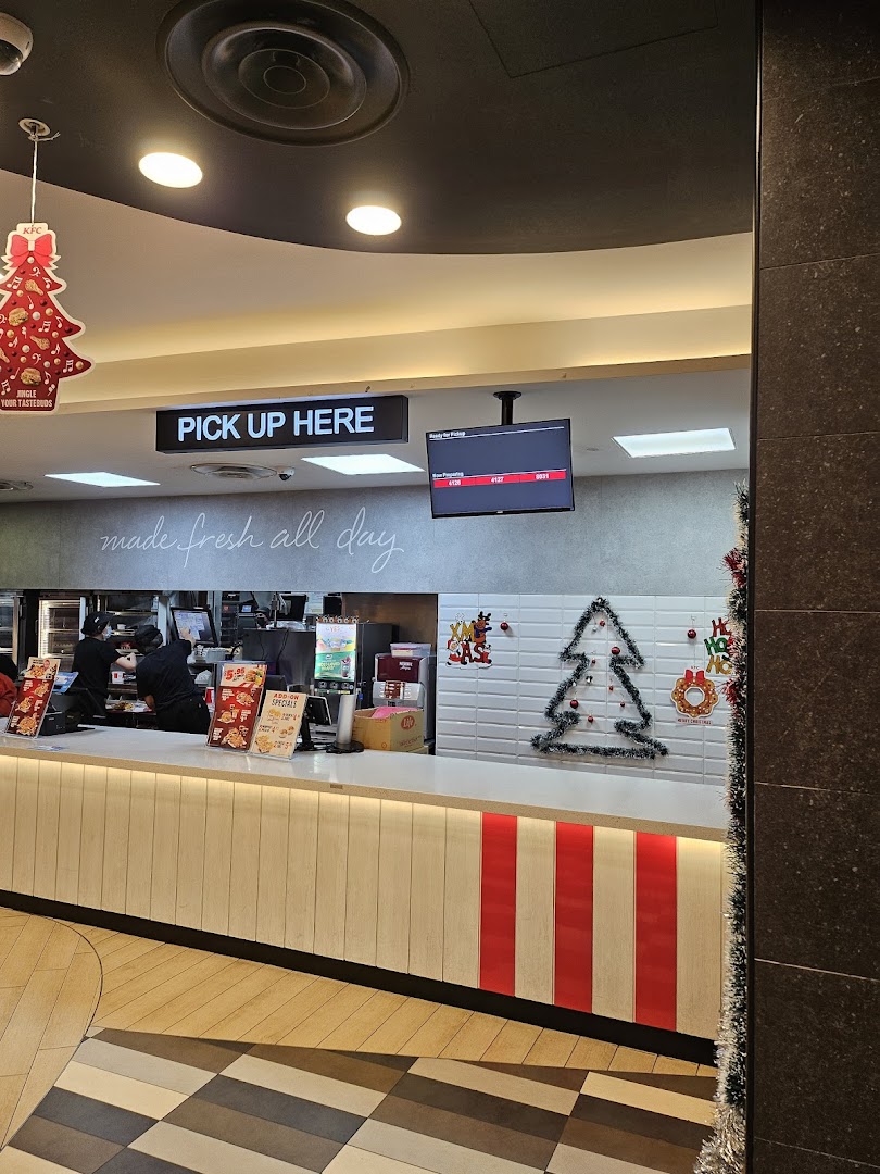 KFC's pick-up counter with festive Christmas decorations and staff preparing orders.