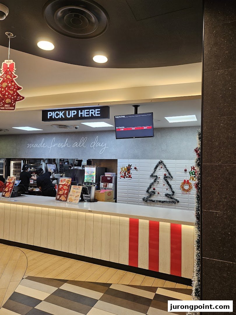 KFC's pick-up counter with festive Christmas decorations and staff preparing orders.