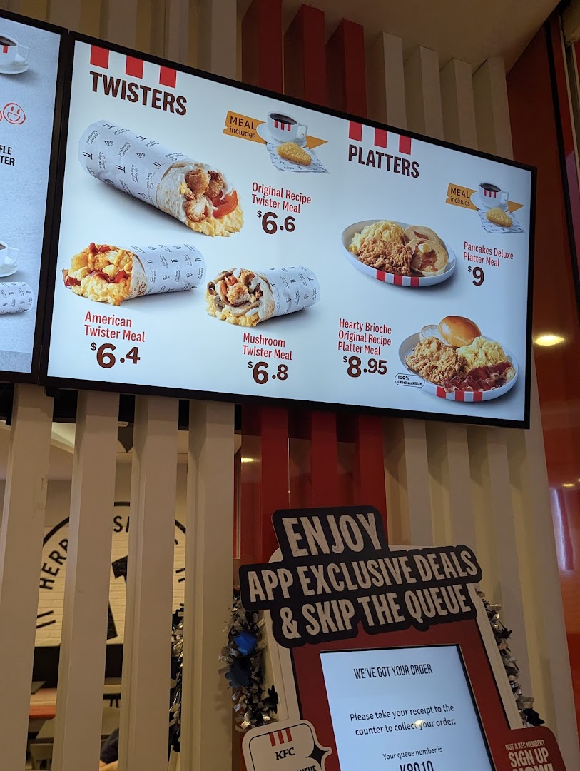 A digital menu board at KFC displaying various Twister and Platter meal options with prices.