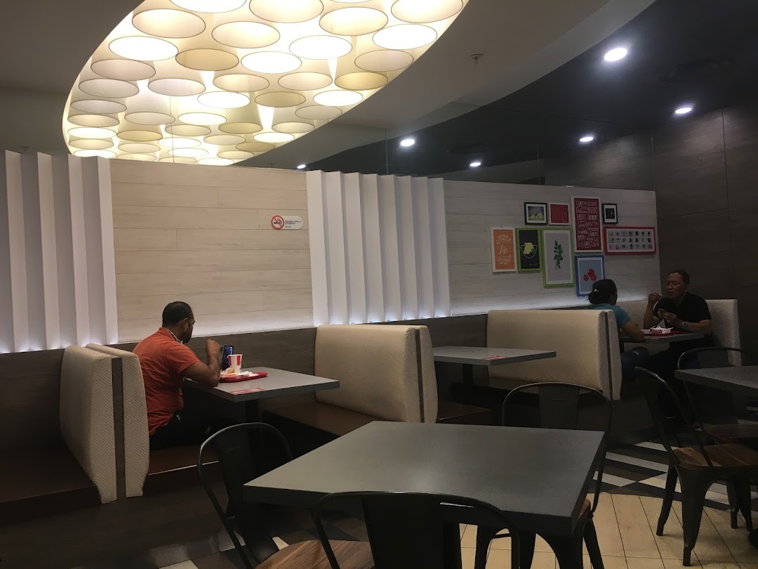 Customers enjoy meals in the modern, well-lit dining area of KFC.