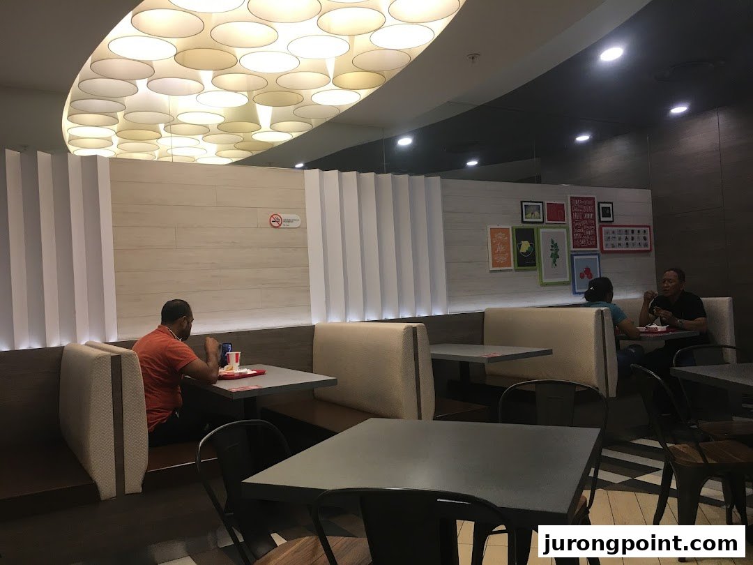 Customers enjoy meals in the modern, well-lit dining area of KFC.