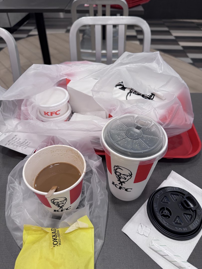 A KFC meal with drinks and packaging on a table, ready to be enjoyed.