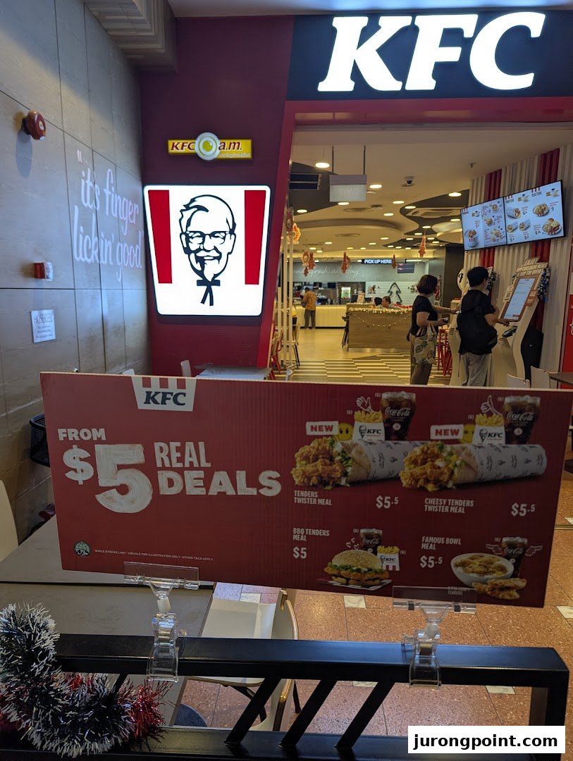 KFC shop entrance featuring a promotional display for 'Real Deals' and a glimpse of the interior.