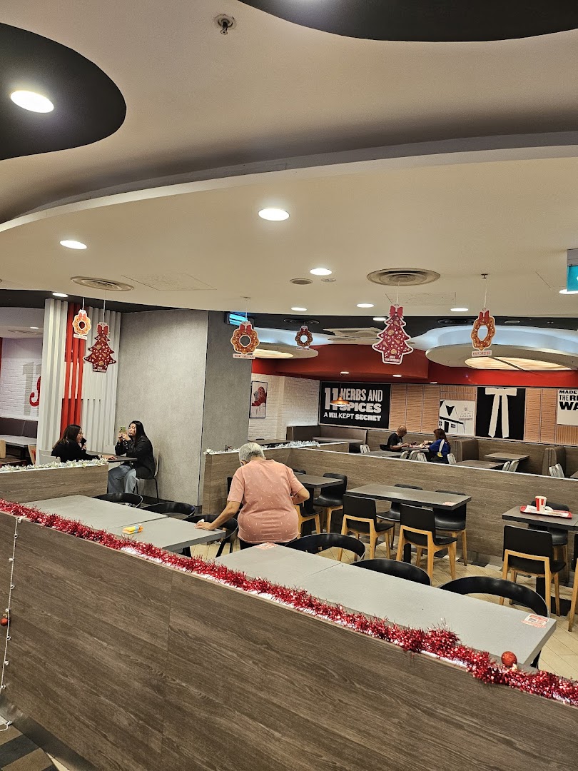 Interior view of KFC dining area with customers and festive Christmas decorations.