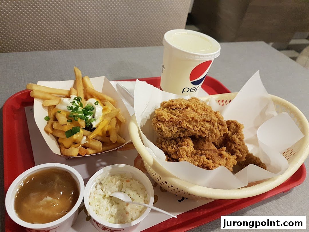 A tray featuring KFC fried chicken, loaded fries, coleslaw, gravy, and a Pepsi drink.
