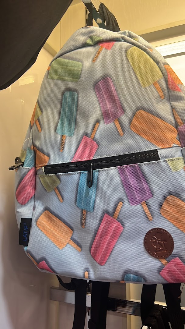 A colorful backpack featuring a playful popsicle pattern, displayed in a retail setting.