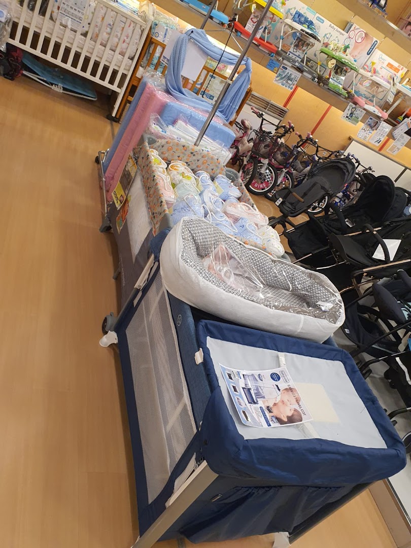An aisle in Kiddy Palace showcasing baby cribs, strollers, and various infant essentials for new parents.