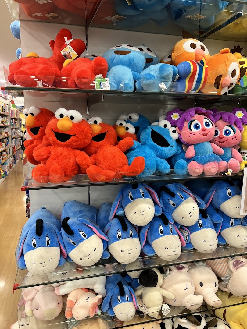 Shelves filled with colorful character plush toys, including Elmo, Cookie Monster, and Eeyore.