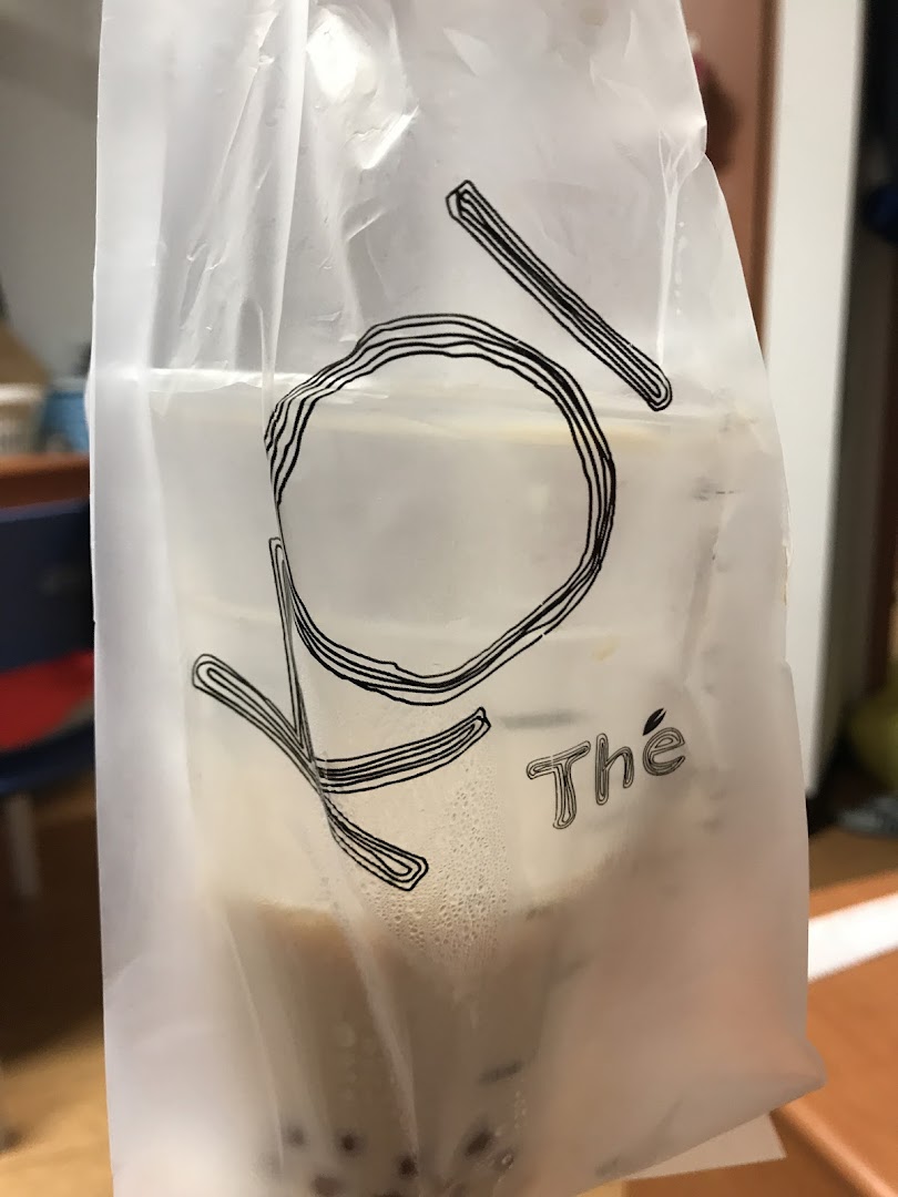 A KOI Thé bubble tea drink in a branded translucent plastic bag, showcasing the beverage inside.