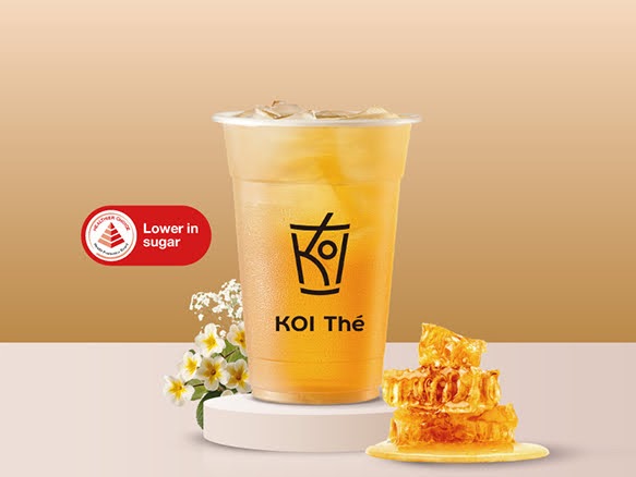 A refreshing honey-based drink from KOI Thé, highlighted as lower in sugar, with honeycomb and flowers.