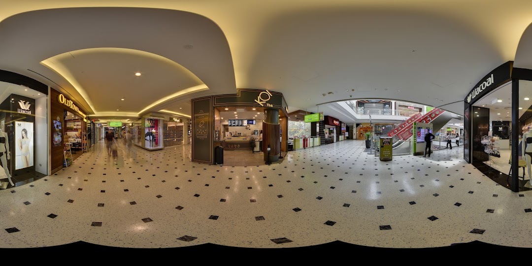 The KOI Thé shop front in a brightly lit shopping mall corridor with other retail stores.