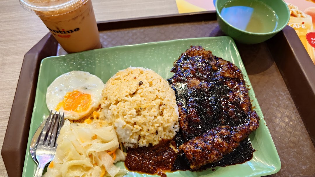 A delicious meal featuring grilled meat, rice, fried egg, and pickled vegetables, served with an iced drink.