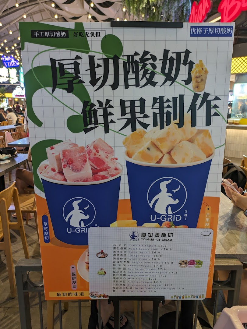 A promotional stand showcasing thick-cut yogurt ice cream with fresh fruit, featuring a detailed menu.
