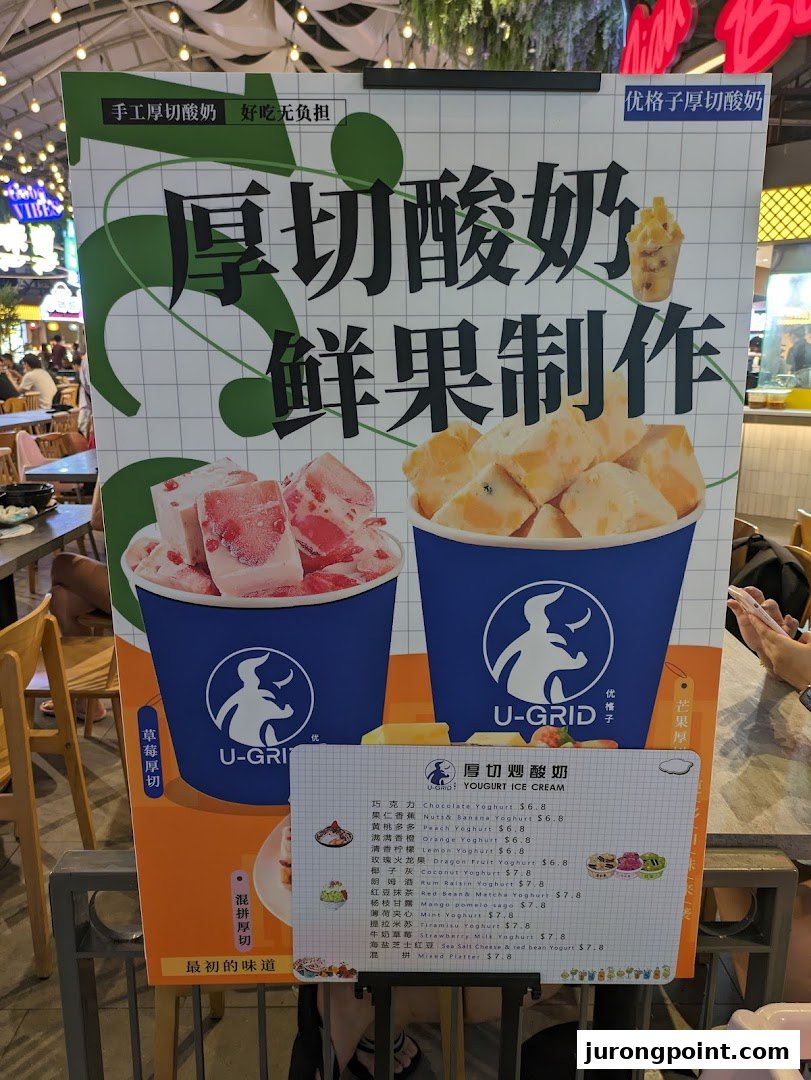 A promotional stand showcasing thick-cut yogurt ice cream with fresh fruit, featuring a detailed menu.