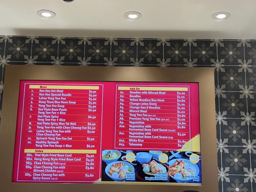 A digital menu board displaying various Asian noodle and Yong Tow Foo dishes with prices.