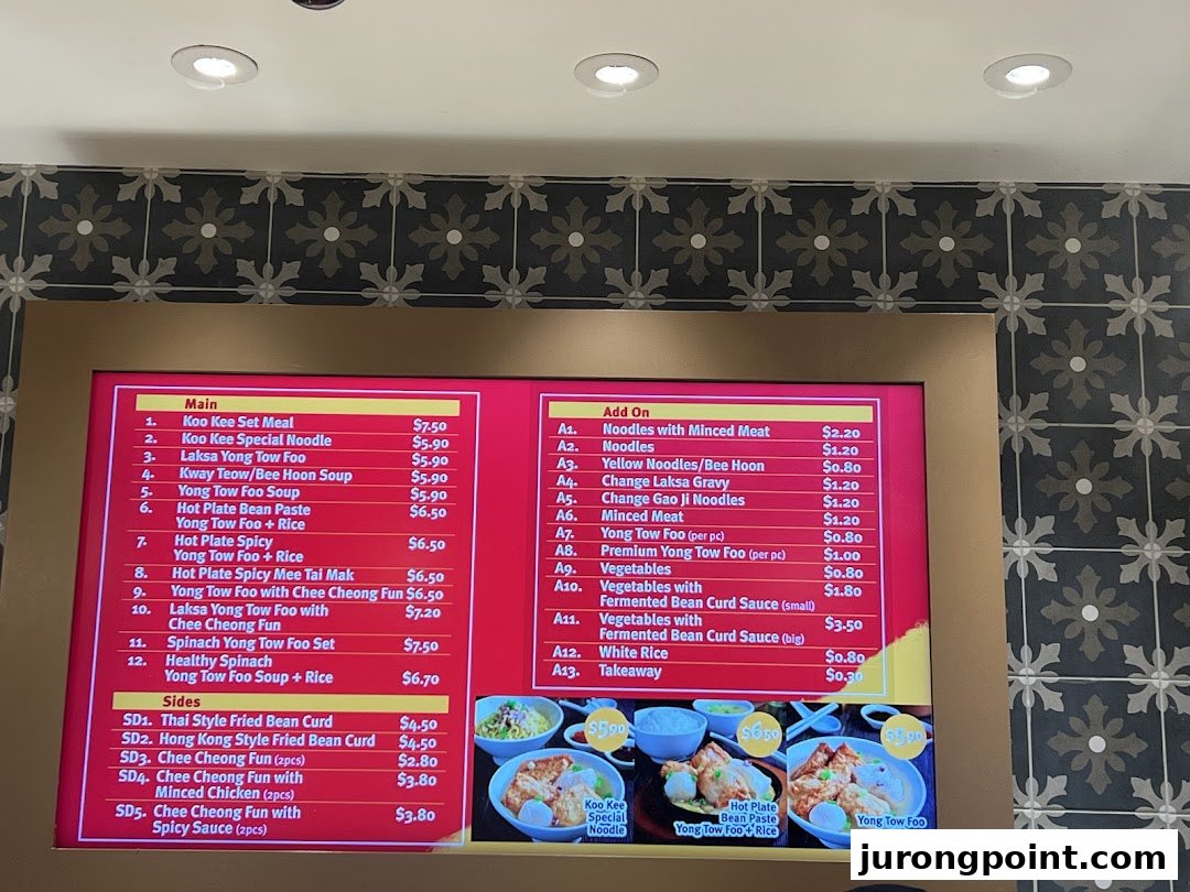 A digital menu board displaying various Asian noodle and Yong Tow Foo dishes with prices.