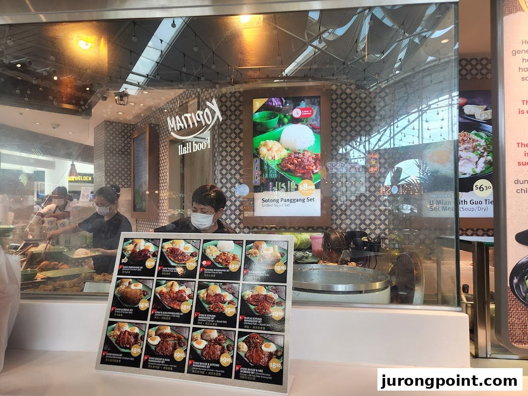 A detailed view of Kopitiam Food Hall's menu display featuring various food sets and prices.