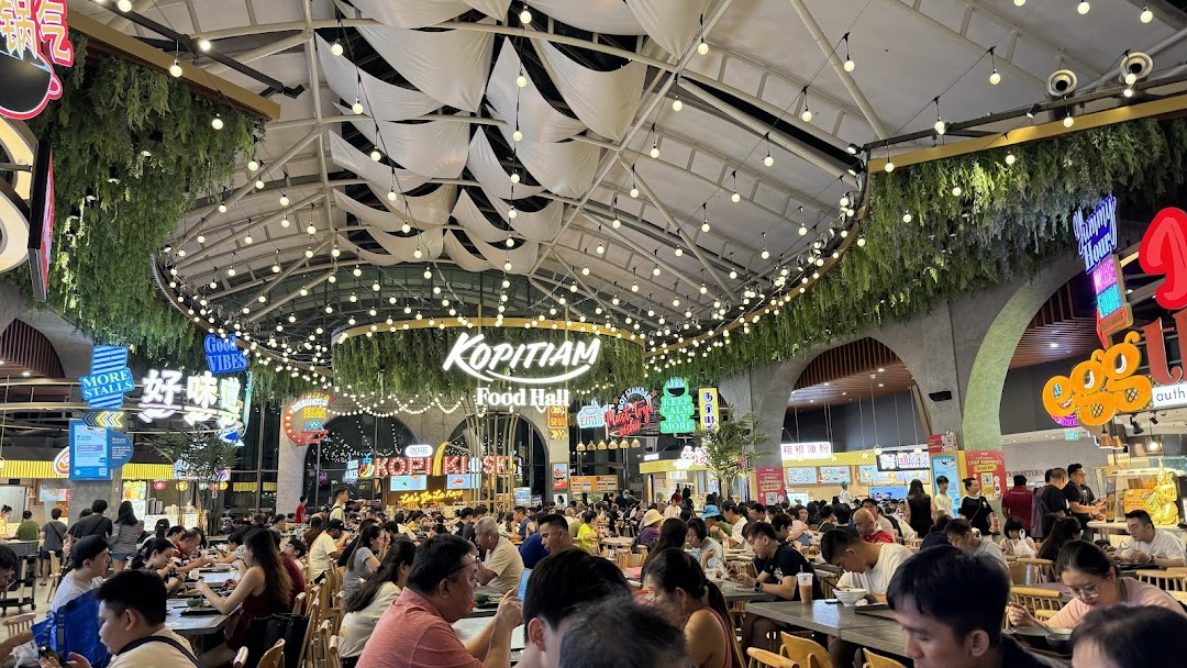 A bustling food hall interior with many patrons dining under a decorative ceiling.