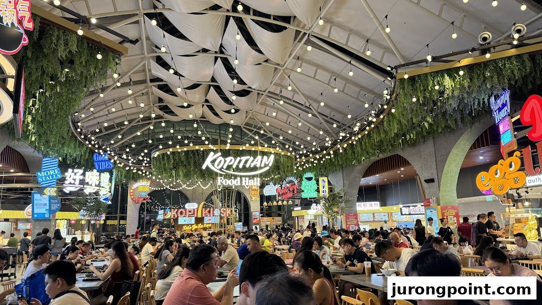 A bustling food hall interior with many patrons dining under a decorative ceiling.