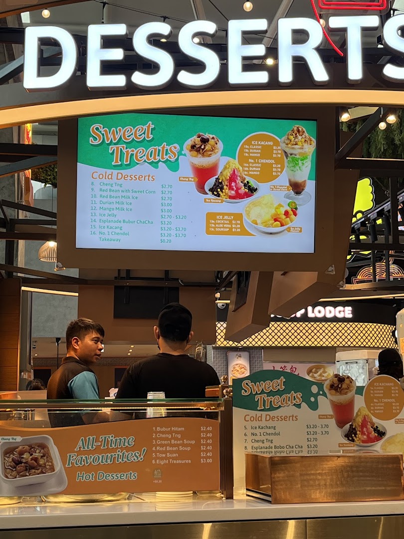 A dessert counter at Kopitiam Food Hall featuring a digital menu board and staff.