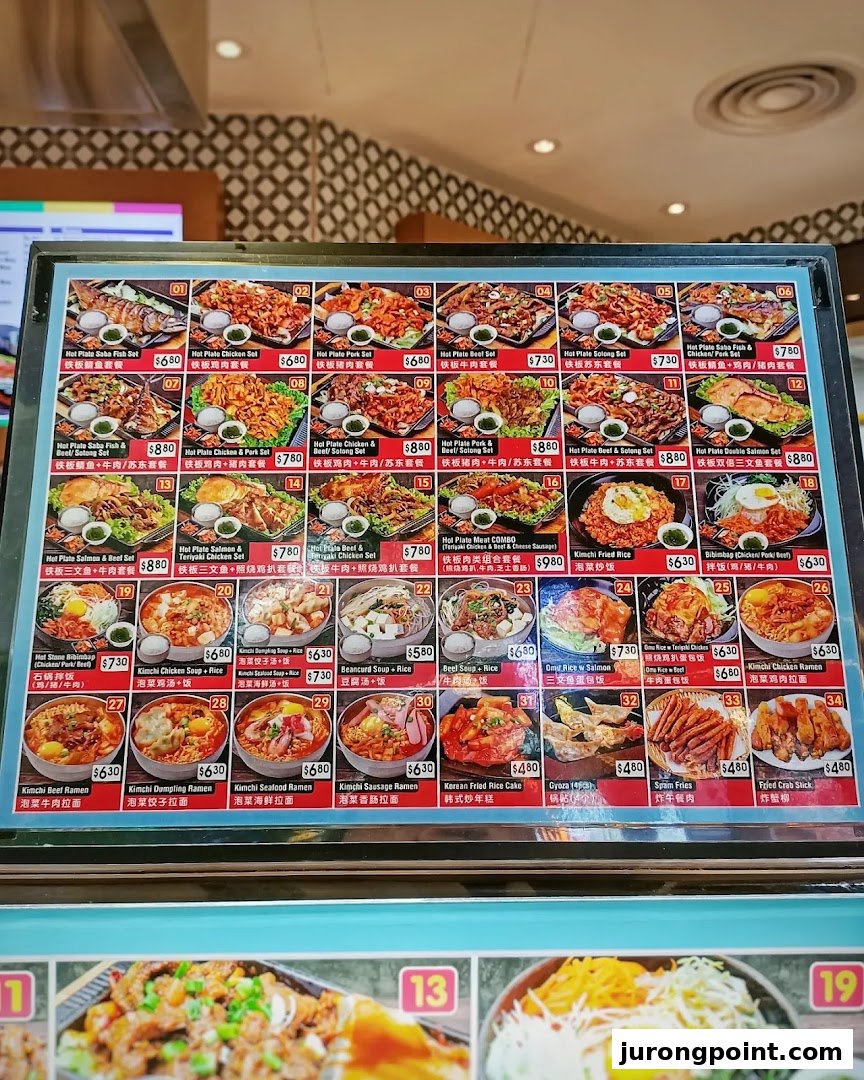 A vibrant menu display showcasing a variety of Korean hot plate sets, rice dishes, soups, ramen, and sides.