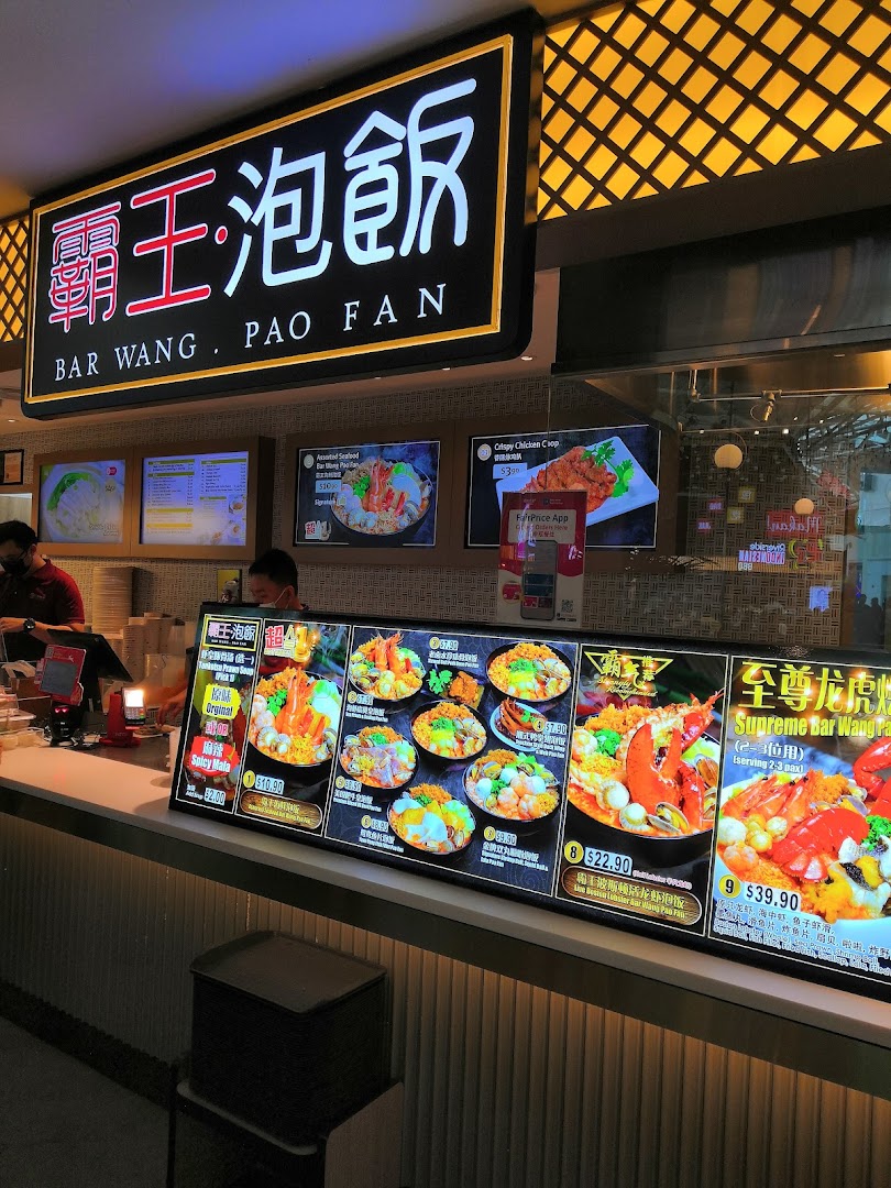 A vibrant food stall interior showcasing a large digital menu display with various Pao Fan dishes.