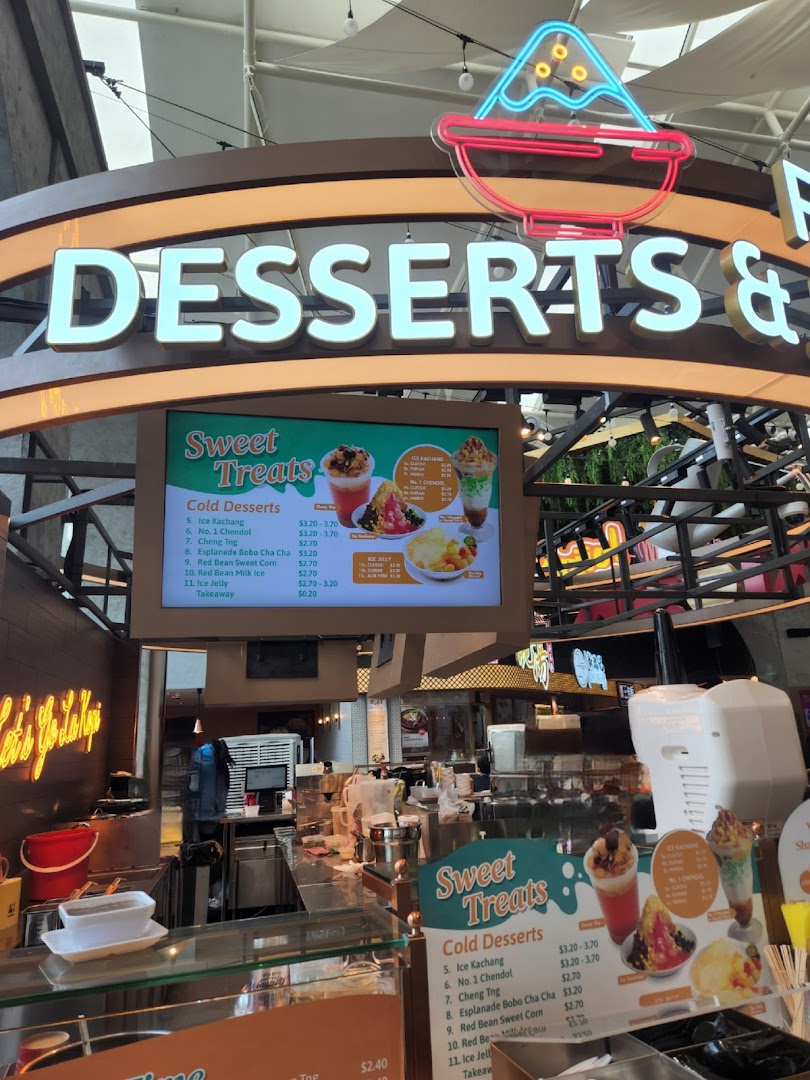 A dessert counter at Kopitiam Food Hall featuring a digital menu board with various cold desserts and prices.