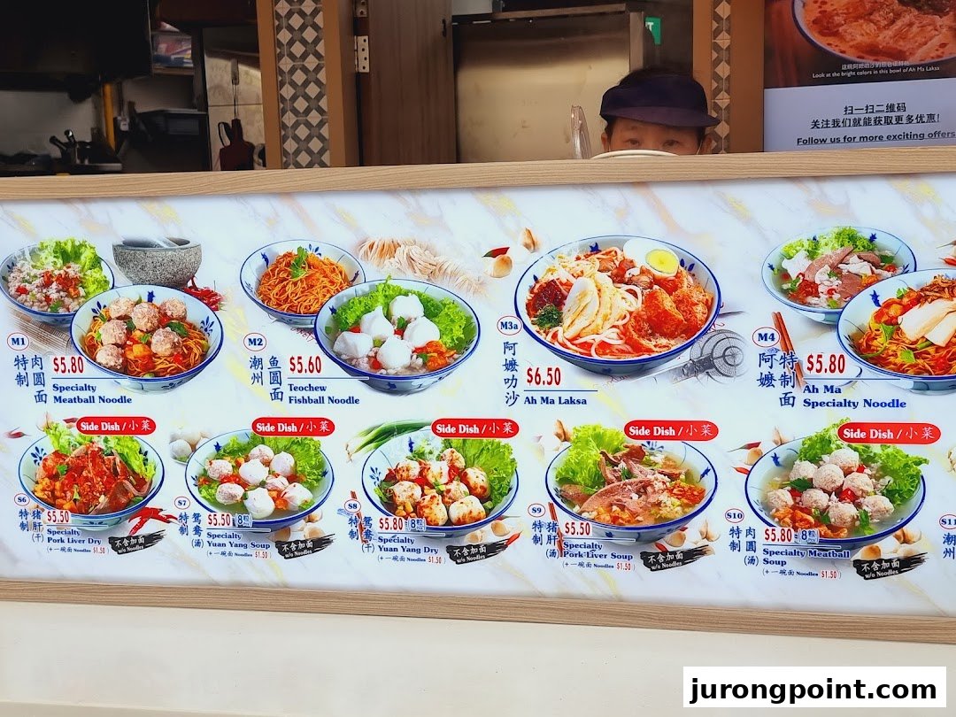 A vibrant menu board showcasing various noodle and side dishes with prices at Kopitiam Food Hall.