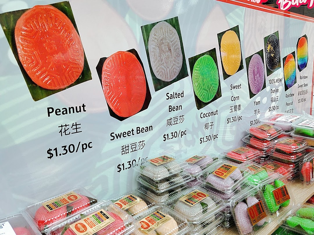 A vibrant display of traditional kueh with various flavors and prices at Kopitiam Food Hall.