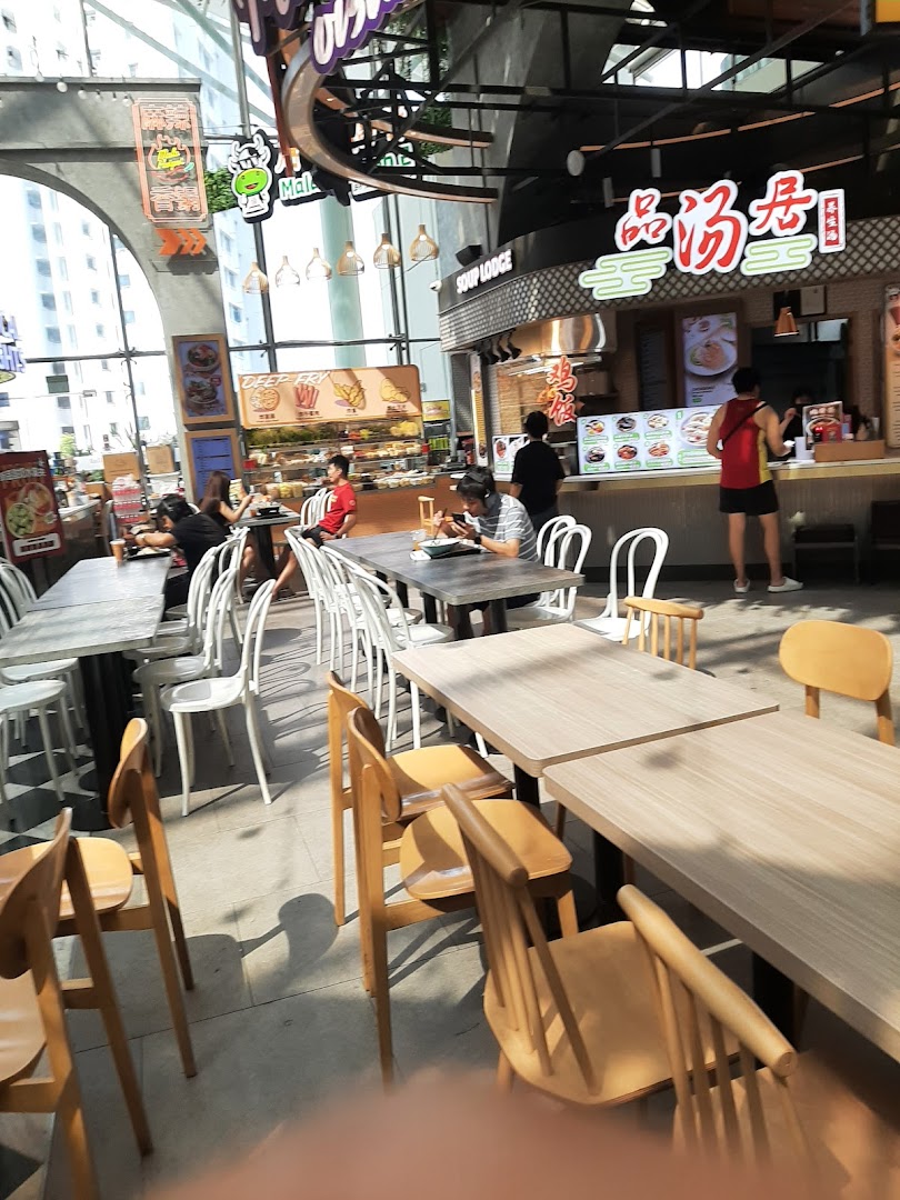 A vibrant interior view of Kopitiam Food Hall with various food stalls and diners.