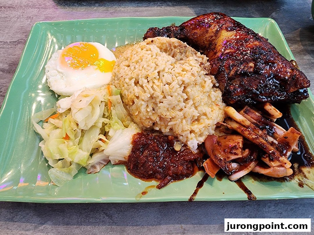A delicious plate featuring rice, grilled chicken, squid, fried egg, and vegetables.
