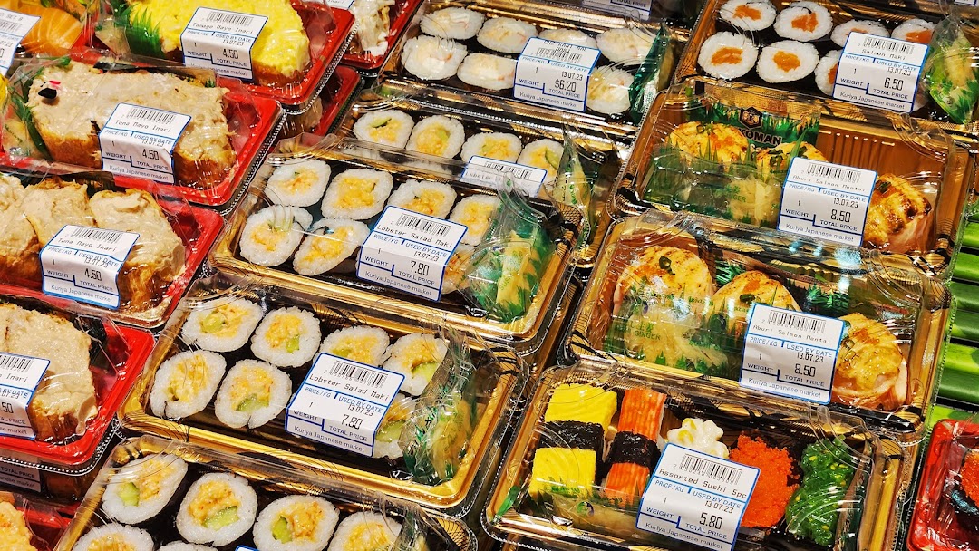 A vibrant display of various pre-packaged sushi, maki, and Japanese food items with price labels.