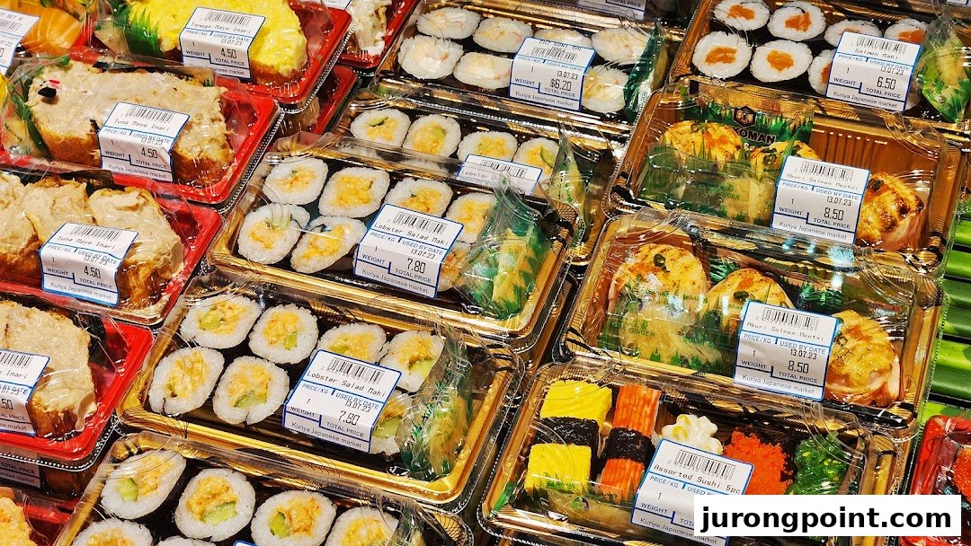 A vibrant display of various pre-packaged sushi, maki, and Japanese food items with price labels.