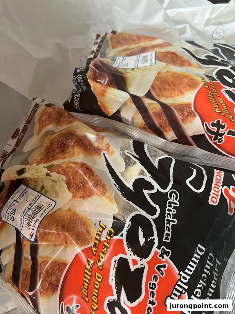 Two bags of frozen Japanese chicken and vegetable gyoza with a price label inside a shopping bag.