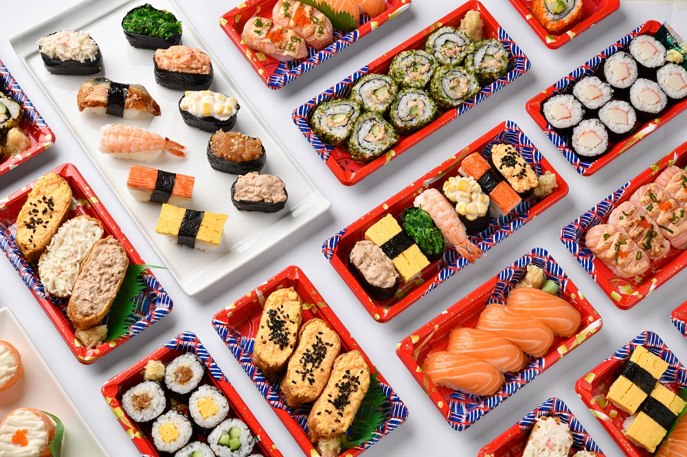 A vibrant overhead view of various Japanese sushi and bento sets, ready for takeaway.