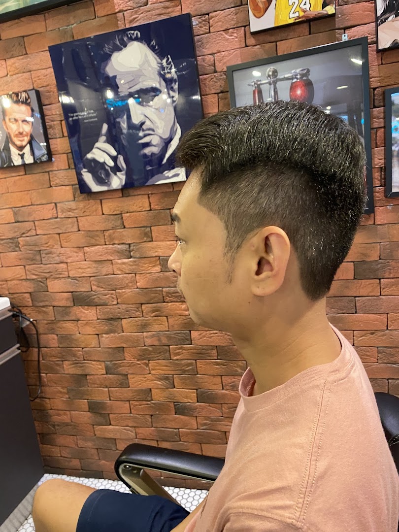 A man showcasing a fresh haircut and fade in a modern barbershop setting.