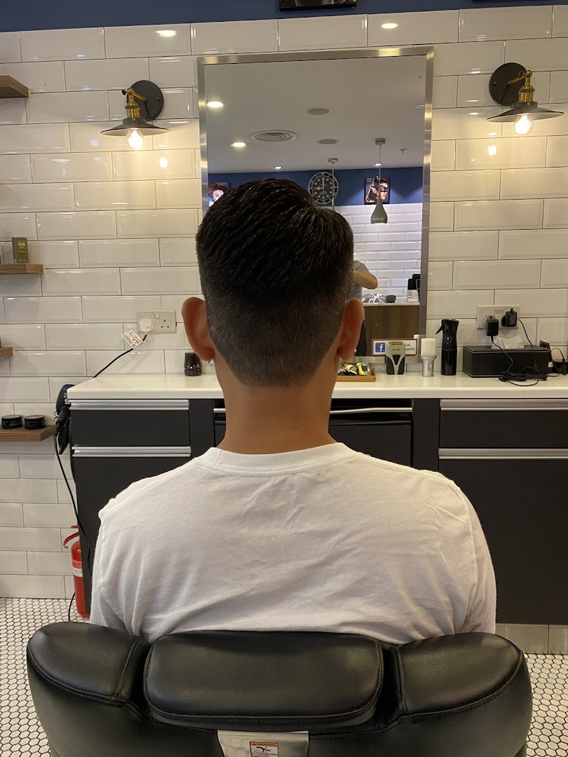 A customer's fresh haircut from behind, showcasing the clean, modern interior of LA Barbershop.