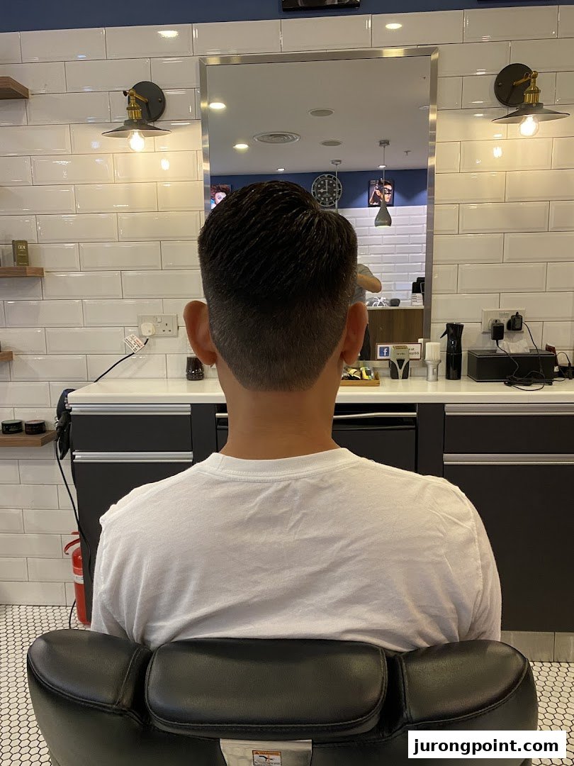 A customer's fresh haircut from behind, showcasing the clean, modern interior of LA Barbershop.