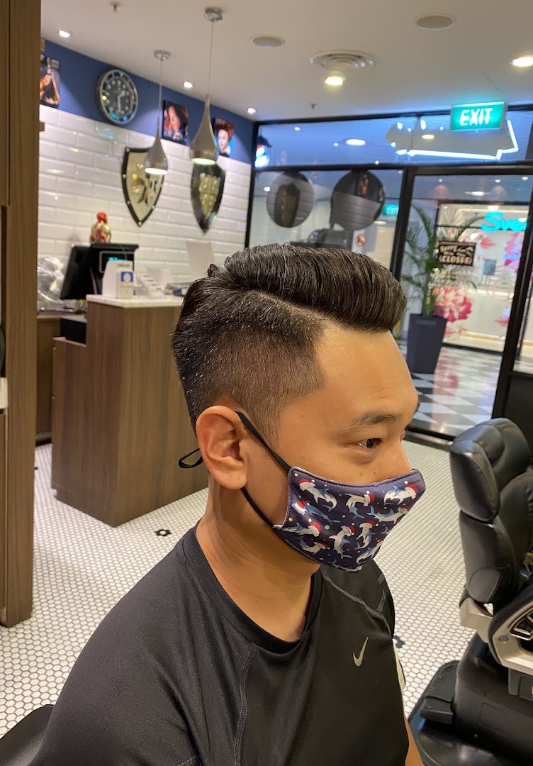 A man with a fresh haircut and fade, wearing a mask, inside LA Barbershop.
