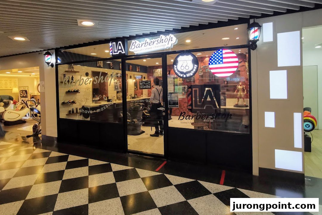 The storefront of LA Barbershop, featuring its entrance, signage, and interior view.
