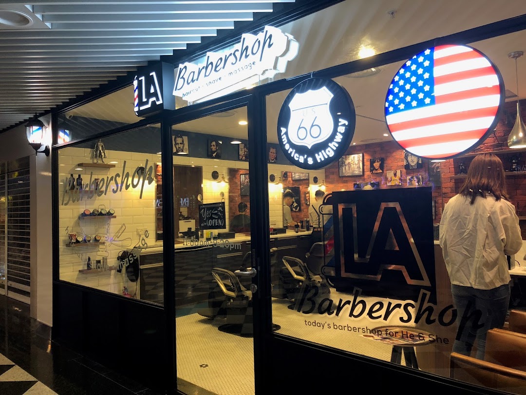 The inviting storefront of LA Barbershop, showcasing its modern interior and classic American-themed decor.