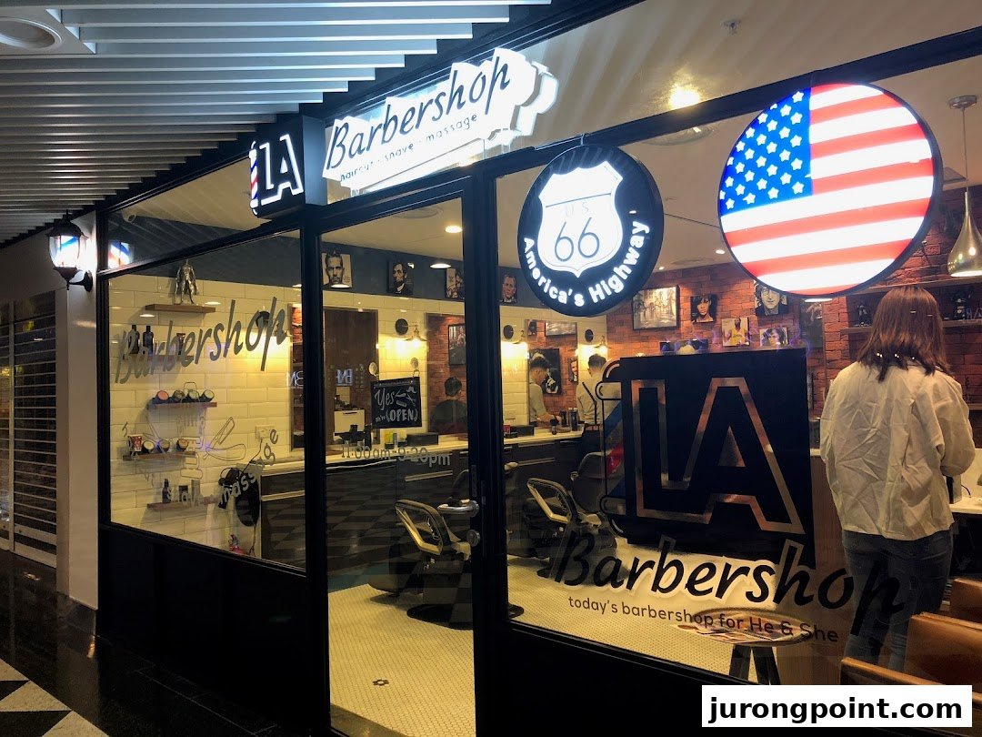 The inviting storefront of LA Barbershop, showcasing its modern interior and classic American-themed decor.