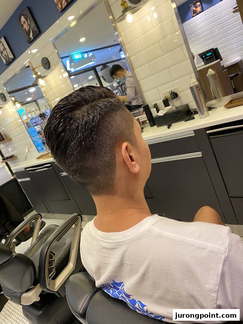 A customer receives a fresh haircut in a modern barbershop setting.