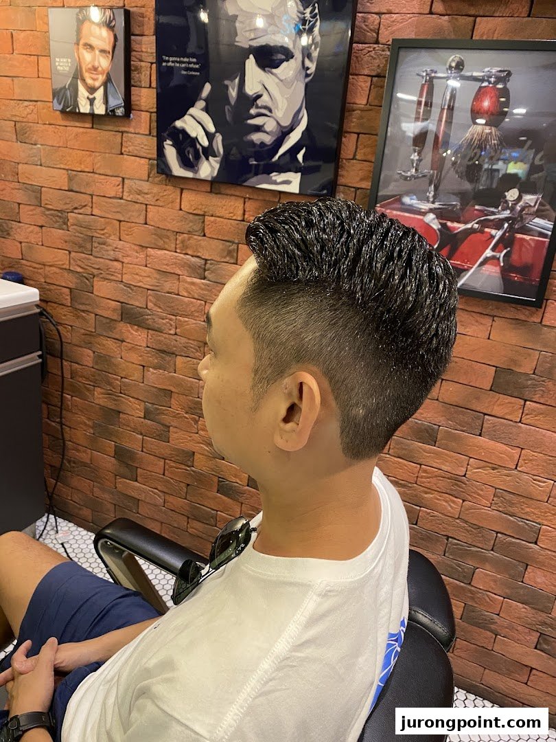 A client showcasing a fresh haircut in a modern barbershop with stylish decor.